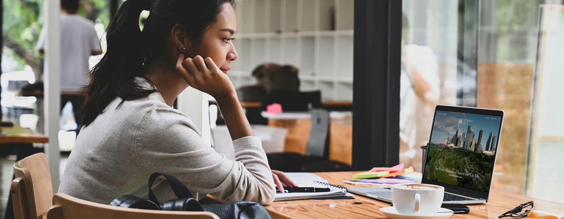 a woman sitting at a table with a laptop