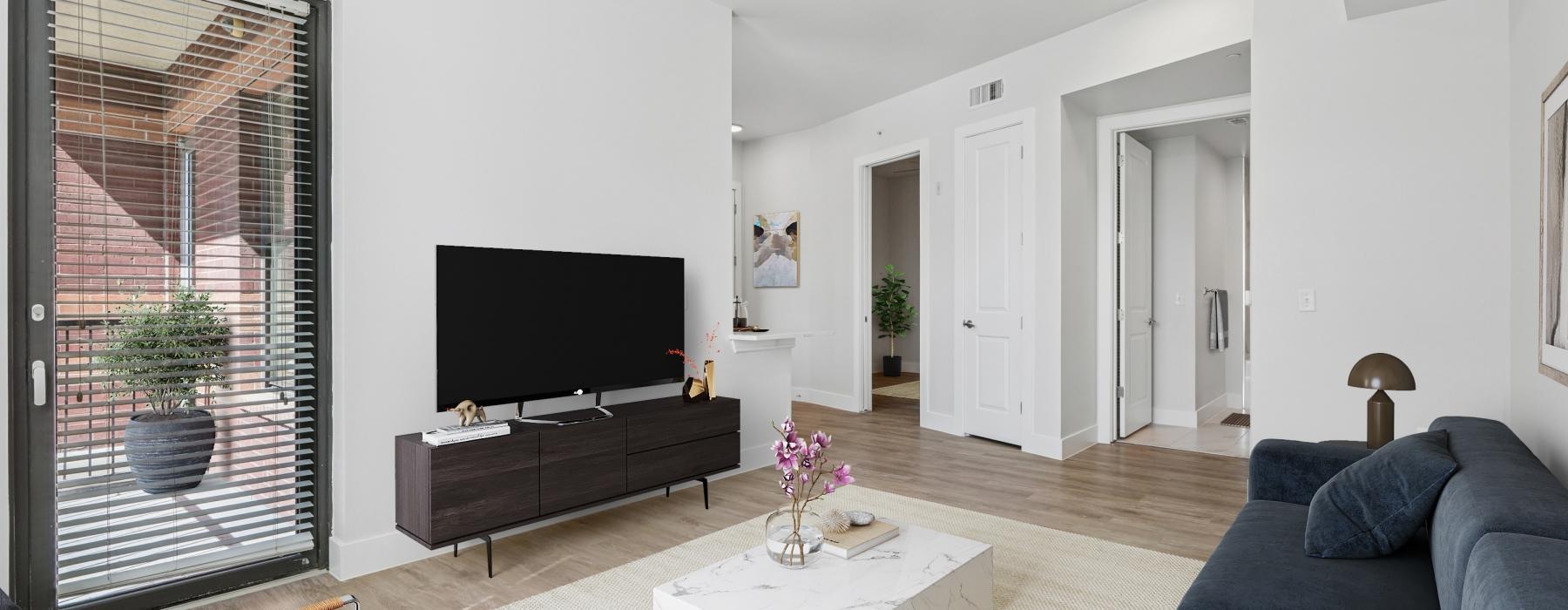View of the  living room with a tv and couches at Memorial Hills Apartments in Houston TX