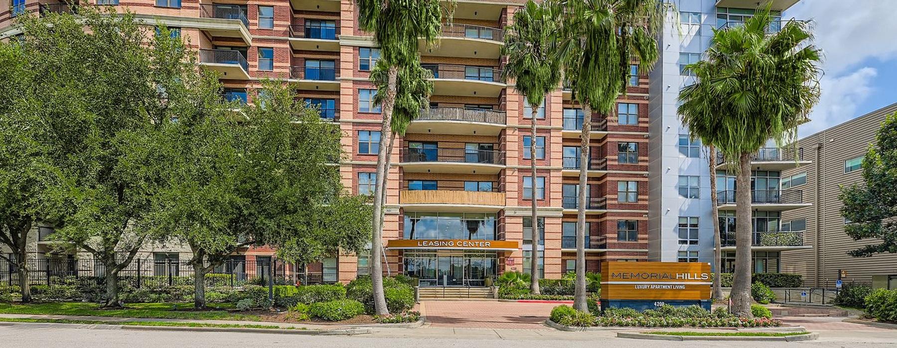 the exterior building of Memorial Hills with palm trees in front of it